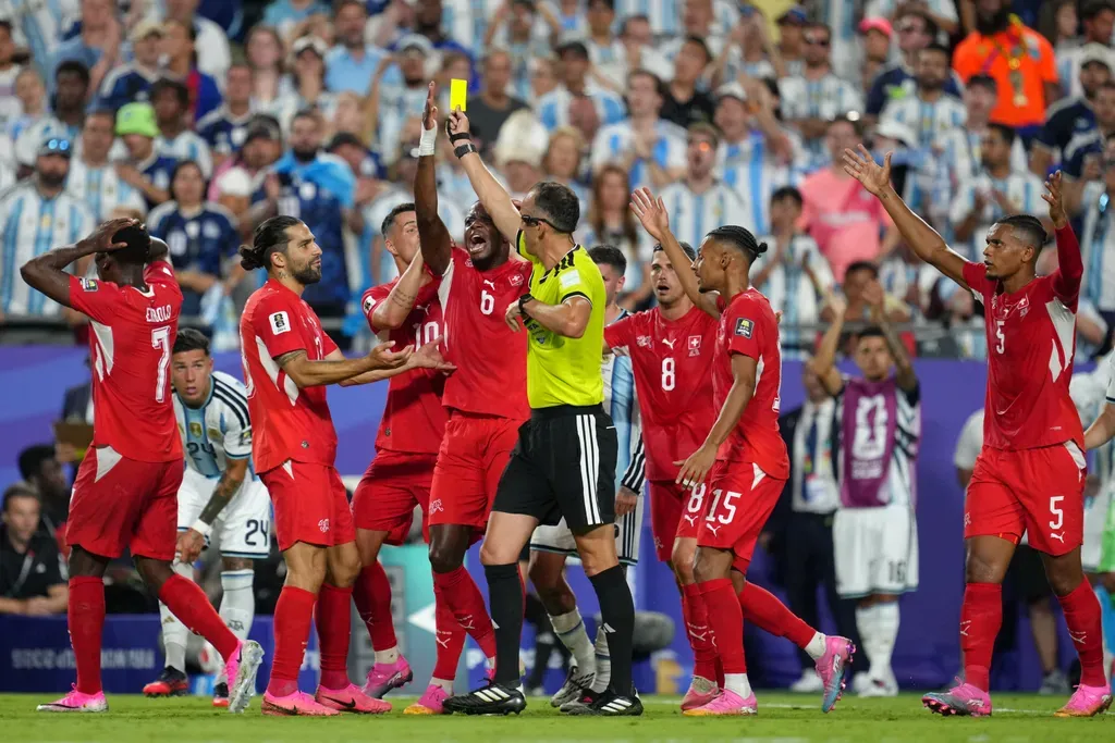 Switzerland's players argue referee Joao Pinheiro, of Portugal, gives a second yellow card to Breel Embolo (7) during the World Cup quarterfinal soccer match between Argentina and Switzerland in Kansas City, Mo., Saturday, July 11, 2026. (AP Photo/Ed Zurga)