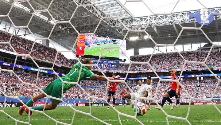 MIAMI GARDENS, FLORIDA - JULY 11: (EDITOR'S NOTE: Image was captured using a remote camera from behind the goal.) Jude Bellingham #10 of England scores his team's second goal past Orjan Nyland #1 of Norway during the FIFA World Cup 2026 Quarter Final match between Norway and England at Miami Stadium on July 11, 2026 in Miami Gardens, Florida. Buda Mendes/Getty Images/AFP (Photo by Buda Mendes / GETTY IMAGES NORTH AMERICA / Getty Images via AFP)