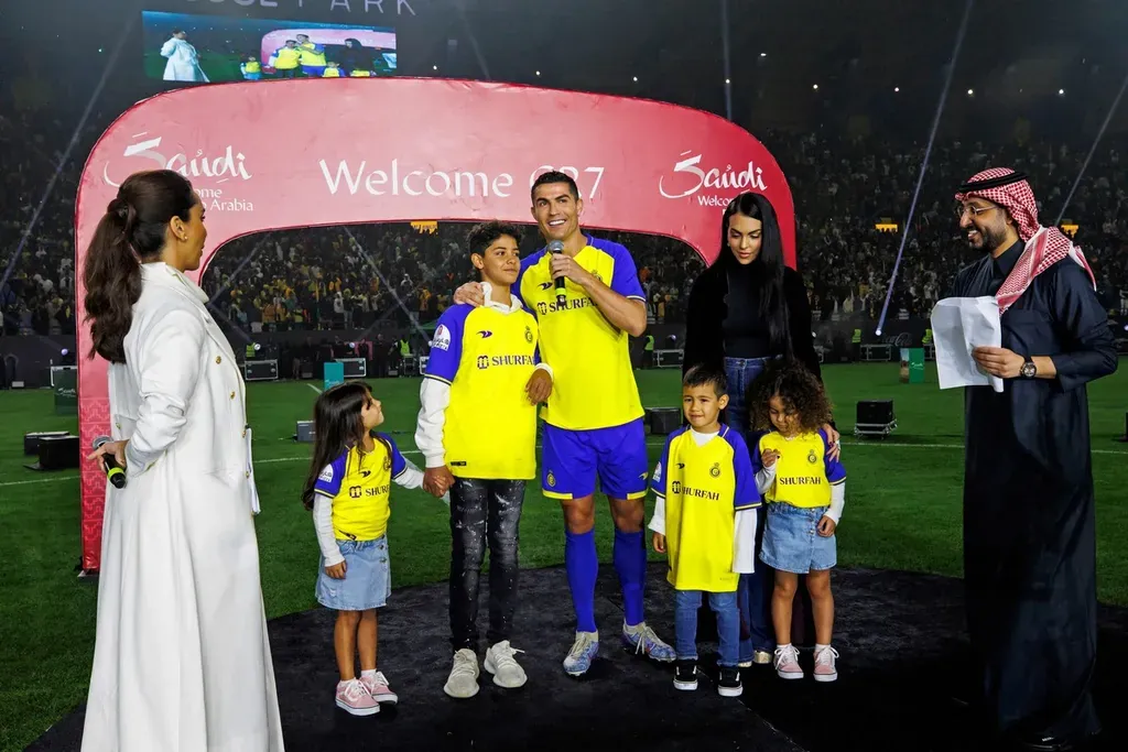 A handout picture released by Saudi Arabia's al-Nassr football club shows Al-Nassr's new Portuguese forward Cristiano Ronaldo (C) alongside his partner Georgina Rodriguez (C-R) and their children standing on the stage during his unveiling at the Mrsool Park Stadium in the Saudi capital Riyadh on January 3, 2023. (Photo by Jorge Ferrari / Al Nassr Football Club / AFP) / == RESTRICTED TO EDITORIAL USE - MANDATORY CREDIT "AFP PHOTO / HO /AL NASSR FOOTBALL CLUB" - NO MARKETING NO ADVERTISING CAMPAIGNS - DISTRIBUTED AS A SERVICE TO CLIENTS ==
